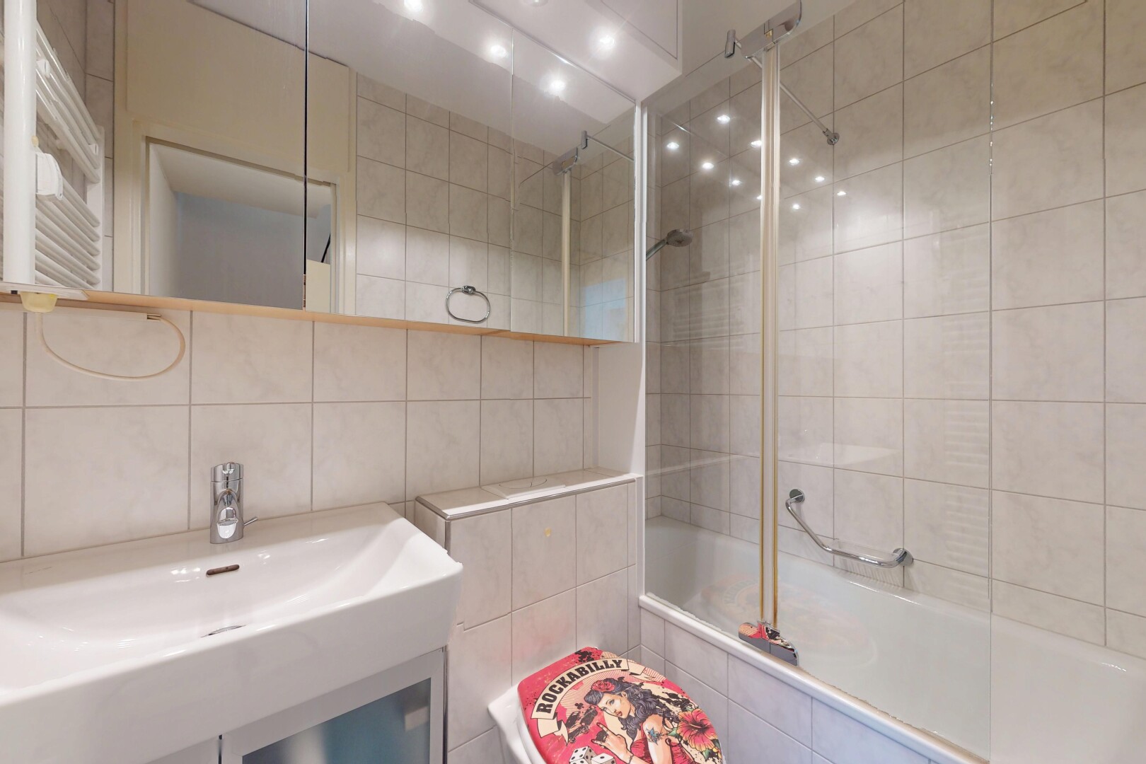 full bathroom featuring tile walls, tiled shower / bath combo, radiator heating unit, and a towel warmer