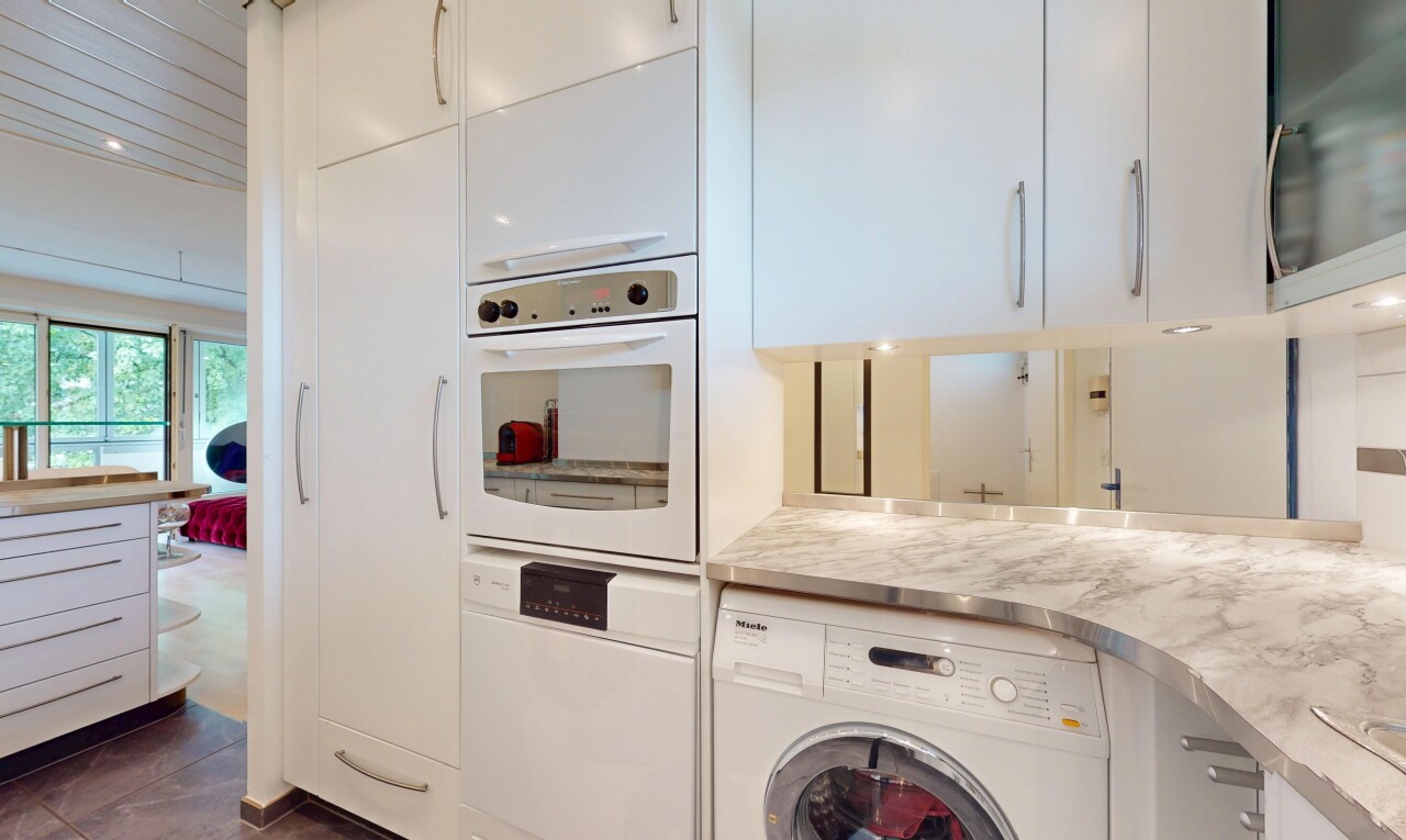 kitchen with washer / dryer, white cabinets, white appliances, and light countertops