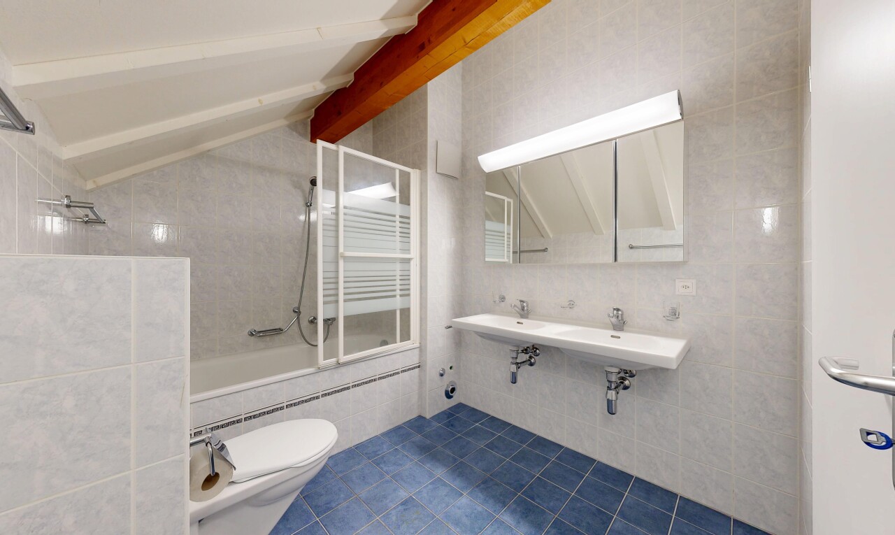 salle de bains avec mur en carrelage, tile wall, miroir, douche-bain combinés, et dark floor