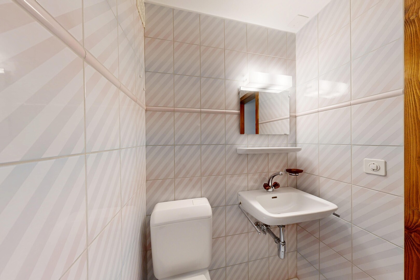 salle de bains avec toilette, miroir, tile wall, mur en carrelage, et évier