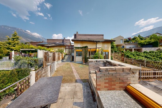 view of property featuring a mountain view, a patio area, and roof mounted solar panels