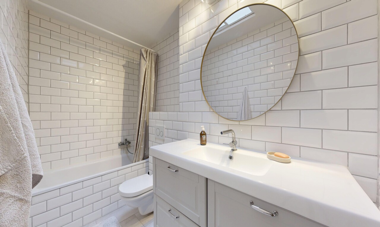 salle de bains avec salle de bain complète, douche-bain combinés, lavabo (ou coiffeuse selon le contexte), toilette, et tile wall