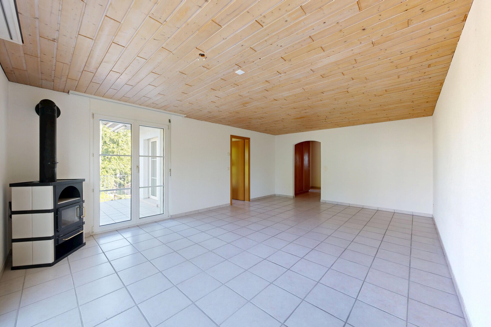leerer raum mit holzdecke, wood ceiling, gewölbte gehwege, light floor, und holzofen