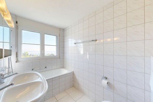 full bathroom featuring tile walls, light tile patterned floors, and a garden tub