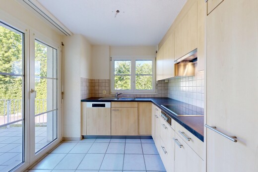 kitchen featuring dark countertops, backsplash, light wood finish cabinetry, and extractor fan