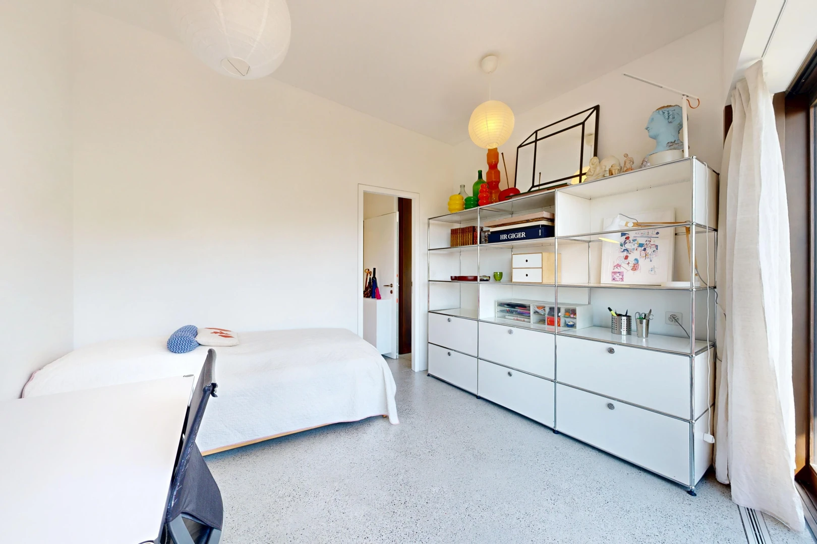 room with dark aggregate flooring and decorative light fixtures