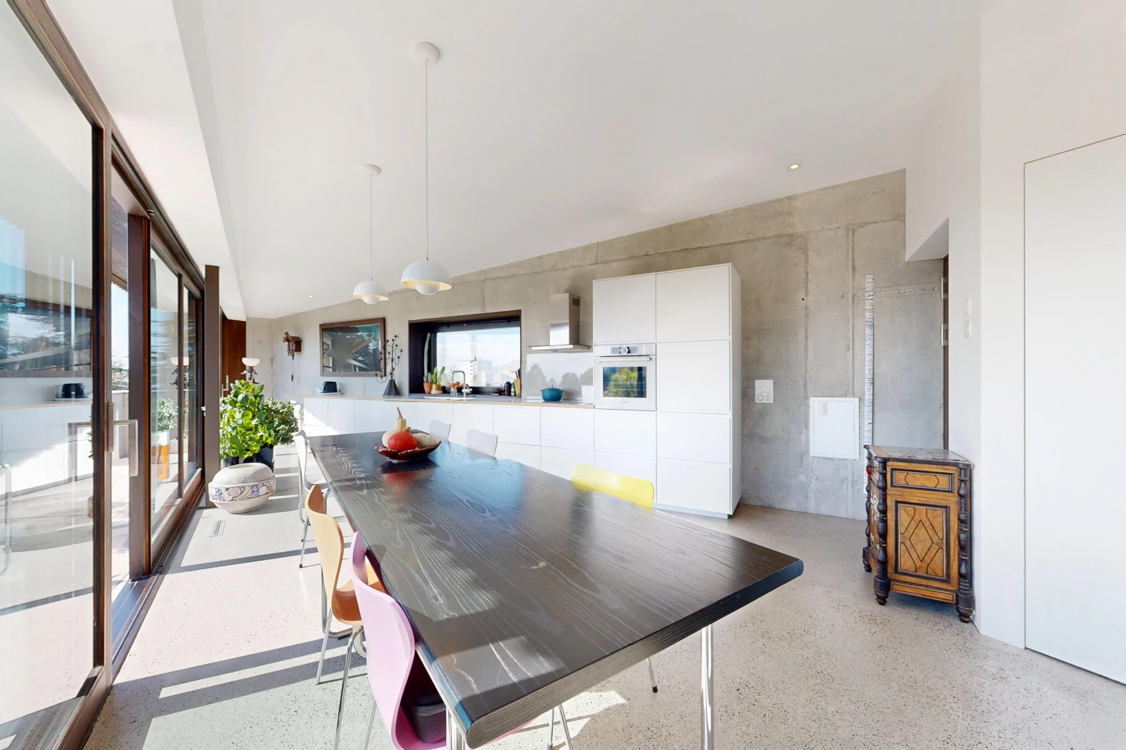 dining room with access to outside, pendant lighting, and dark speckled floor