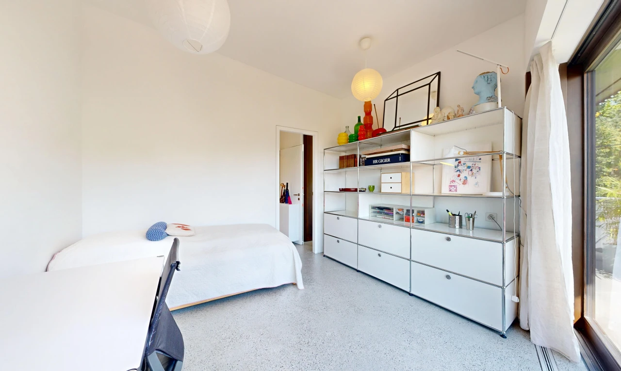 room with dark aggregate flooring and decorative light fixtures