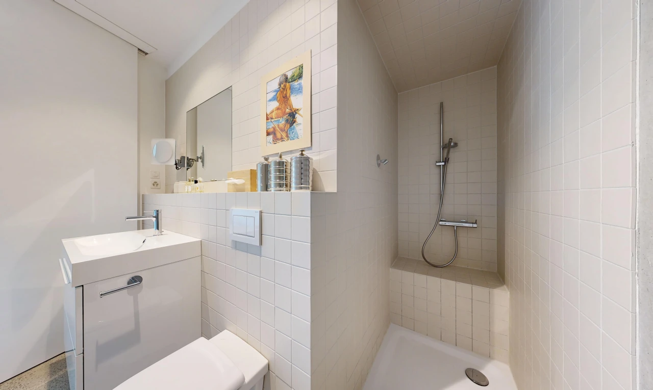 full bathroom featuring tiled shower and vanity