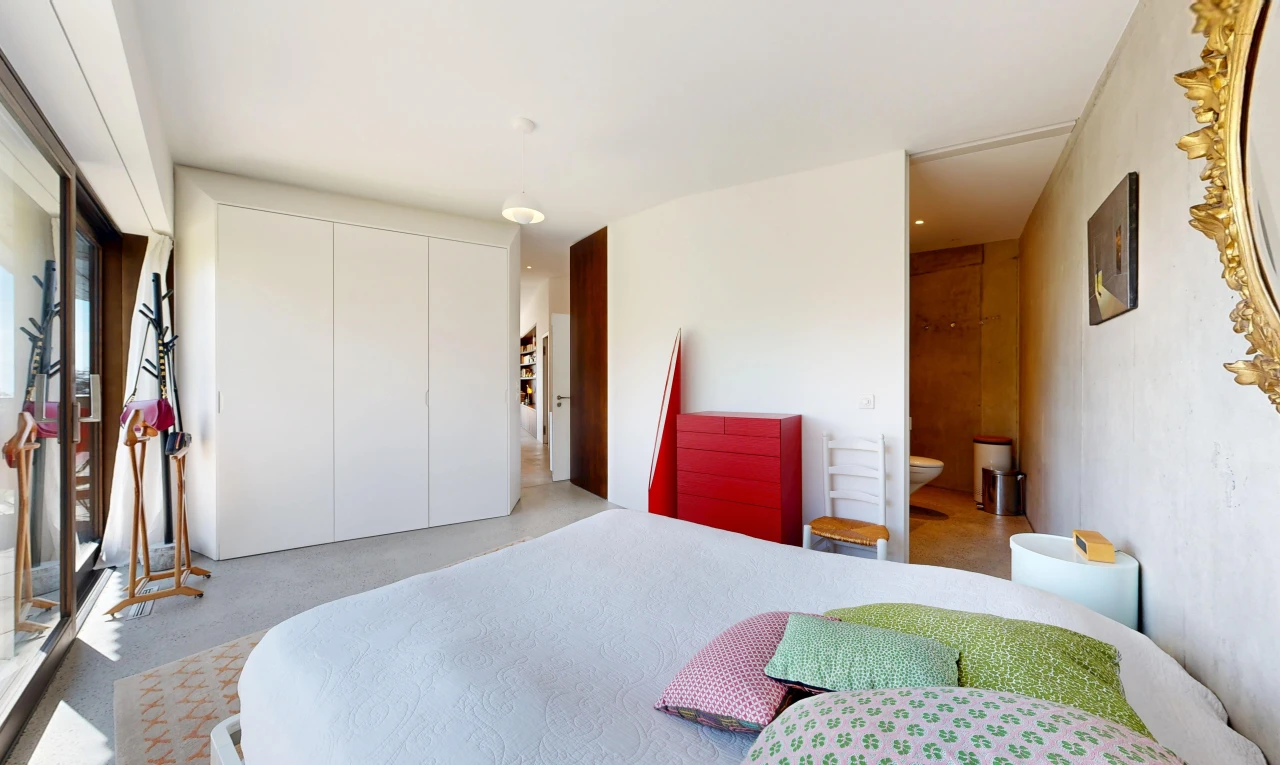 room featuring a closet, decorative light fixtures, and ensuite bath