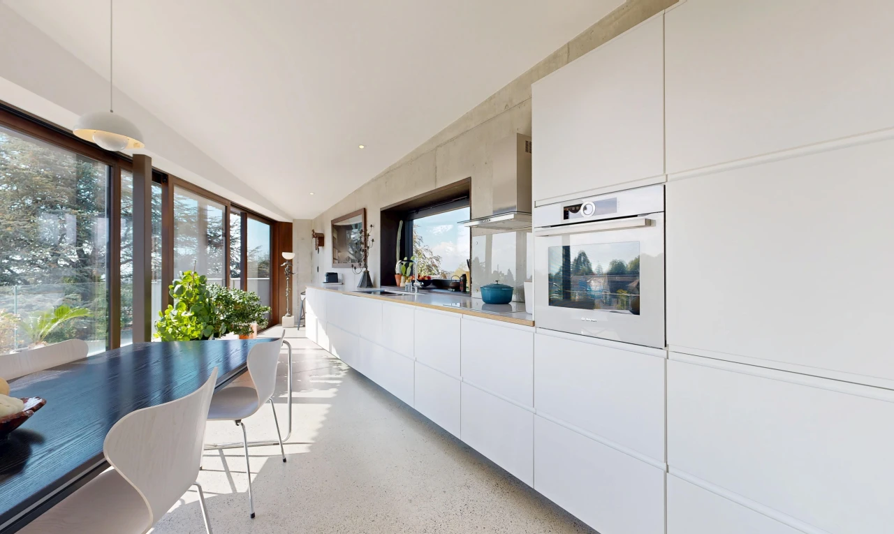 kitchen featuring hanging light fixtures, white oven, dark aggregate flooring, light countertops, and white cabinets