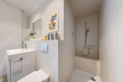 full bathroom featuring tiled shower and vanity