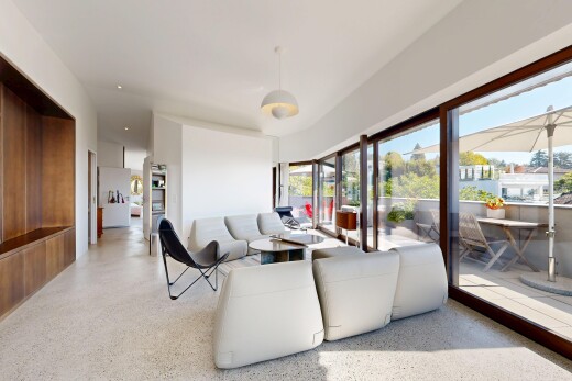 living area featuring dark aggregate flooring, hanging light fixtures, and access to exterior