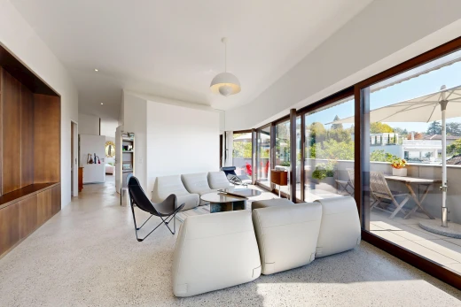 living area featuring dark aggregate flooring, hanging light fixtures, and access to exterior