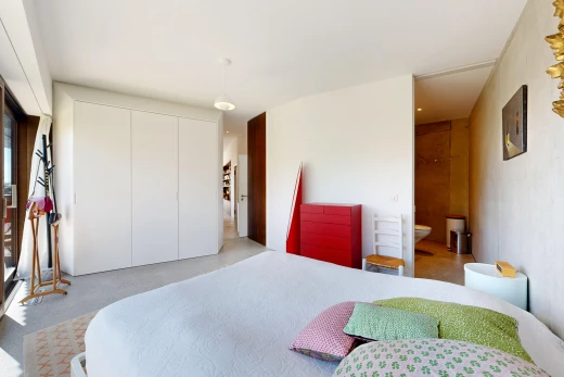 room featuring a closet, decorative light fixtures, and ensuite bath