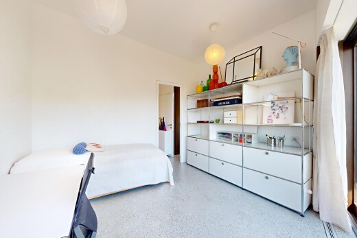 room with dark aggregate flooring and decorative light fixtures