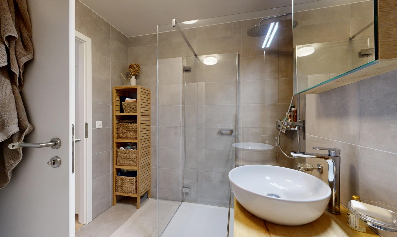 full bathroom featuring a stall shower, vanity, and tile walls