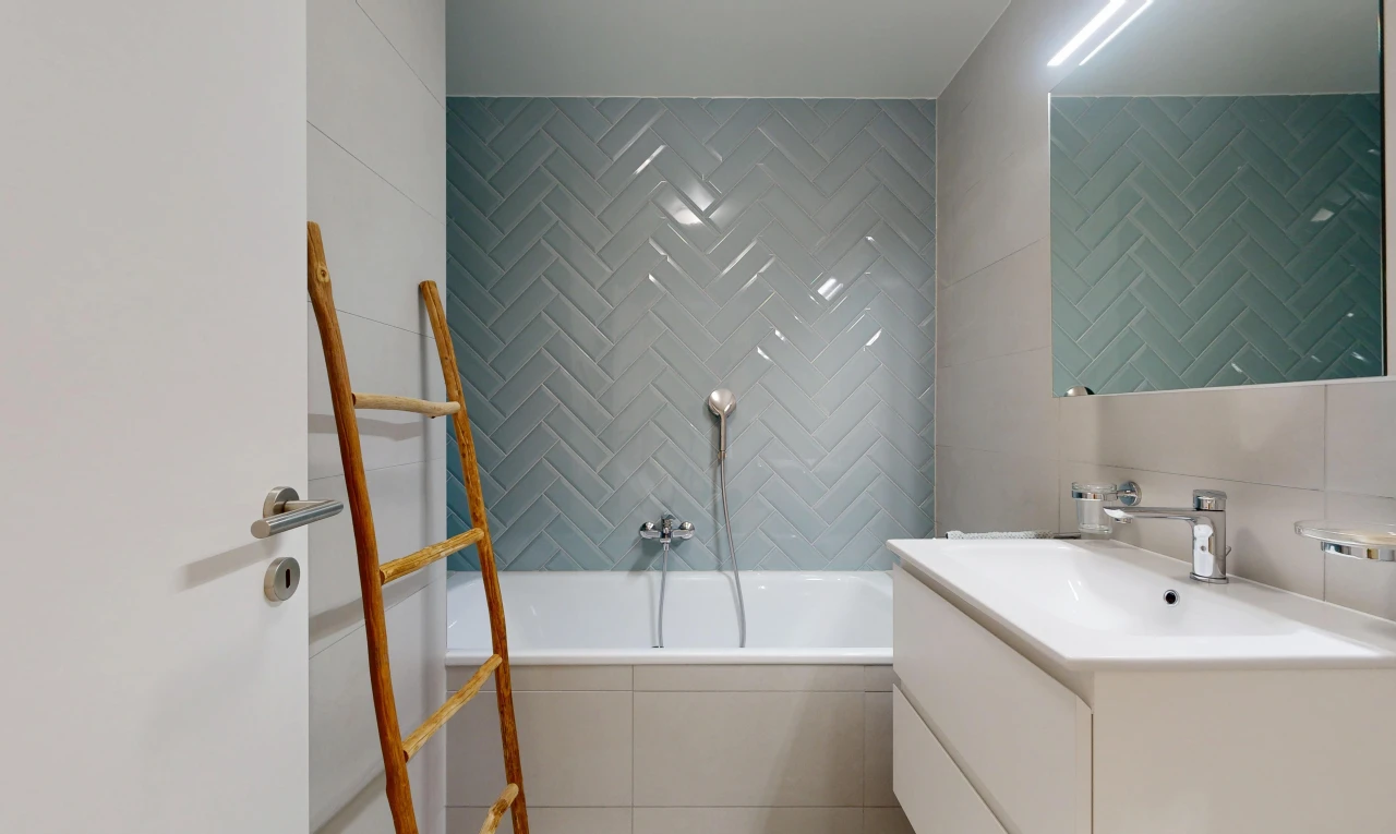 bathroom with a garden tub, vanity, and tile walls