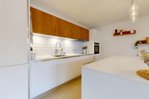 dual tone kitchen featuring two tone cabinets, light countertops, modern cabinets, oven, and decorative backsplash