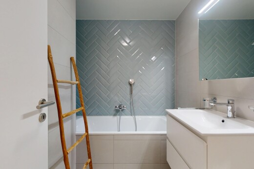 bathroom with a garden tub, vanity, and tile walls