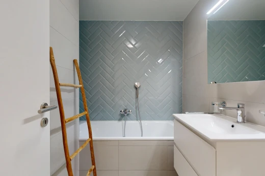 bathroom with a garden tub, vanity, and tile walls