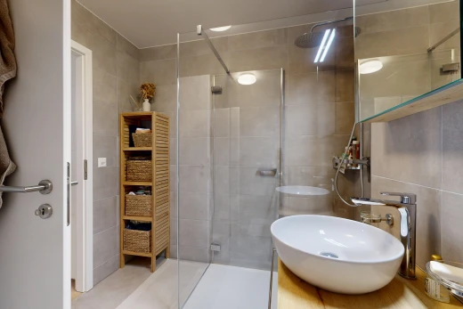full bathroom featuring a stall shower, vanity, and tile walls