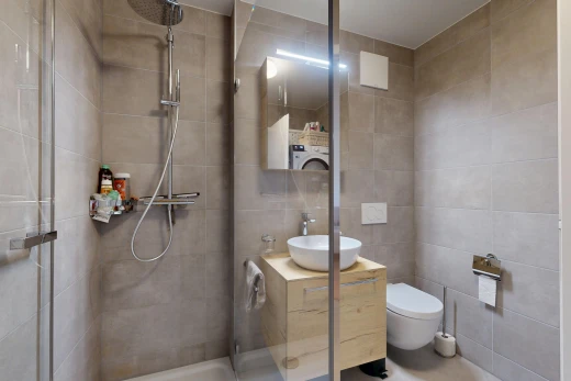 full bathroom featuring a shower stall, tile walls, vanity, and washer / dryer