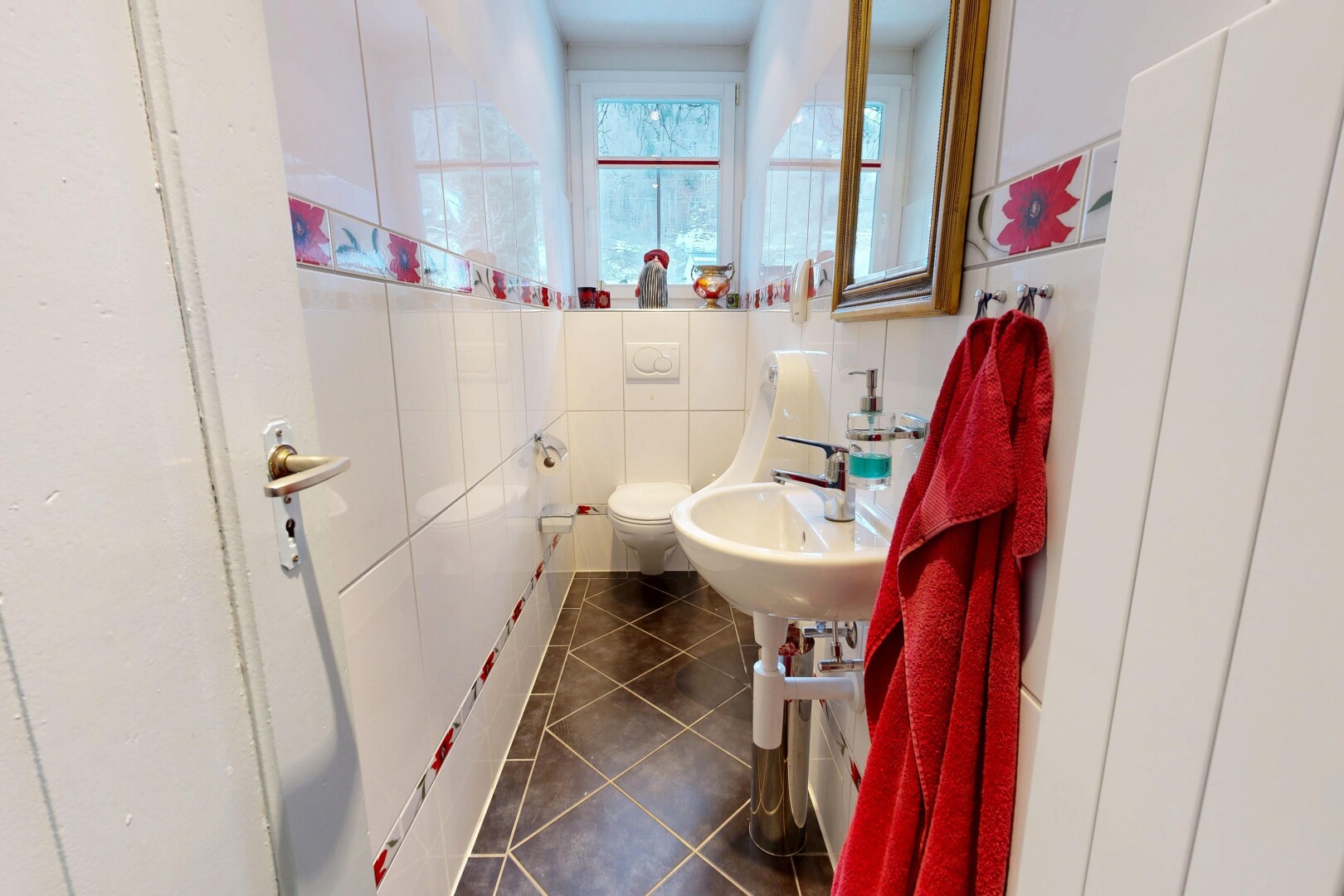 salle de bains avec toilette, dark floor, tile floor, sol en carrelage, et natural light