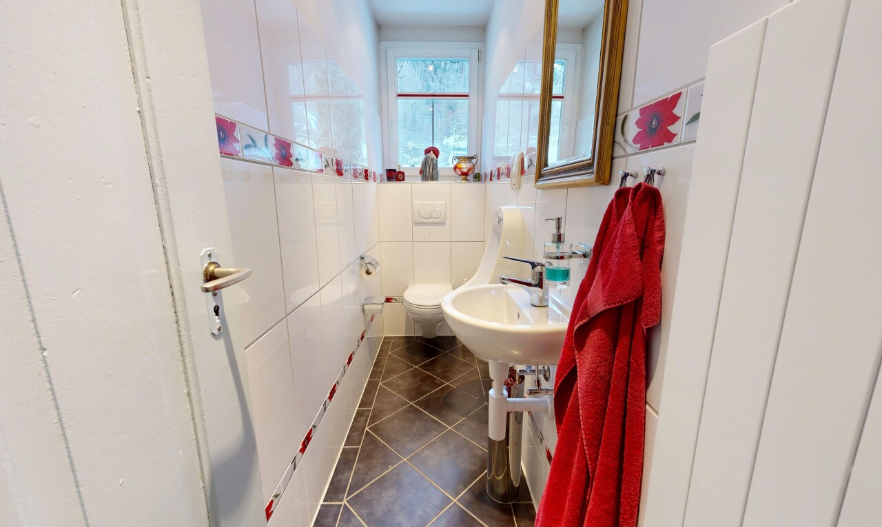 salle de bains avec toilette, dark floor, tile floor, sol en carrelage, et natural light