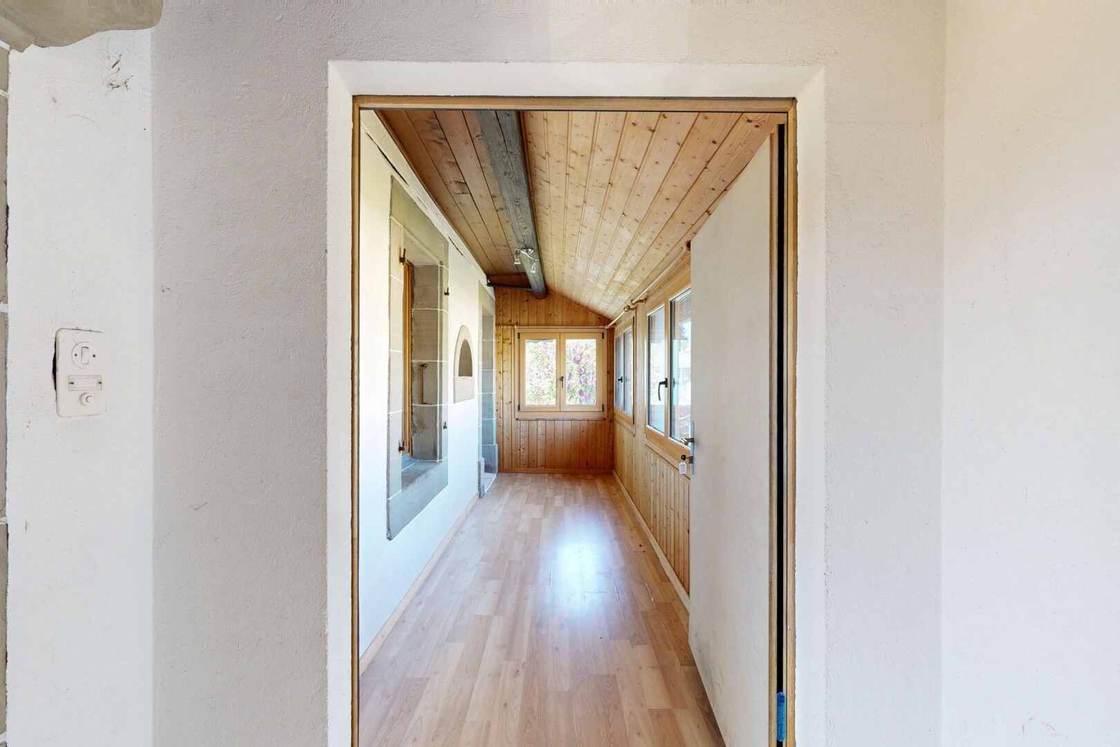 couloir avec wood ceiling, plafond en bois, vaulted ceiling, plafond voûté, et wood finish floor