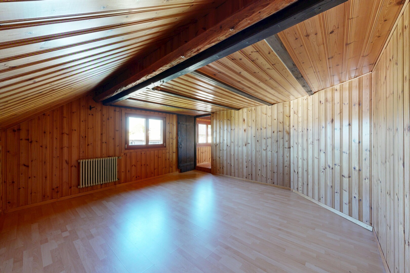 pièce vide avec sol en finition bois, wood finish floor, radiateur, lumière naturelle, et natural light
