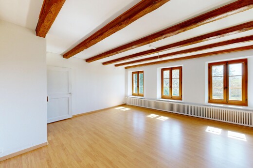 empty room featuring radiator, light wood-style floors, and beamed ceiling