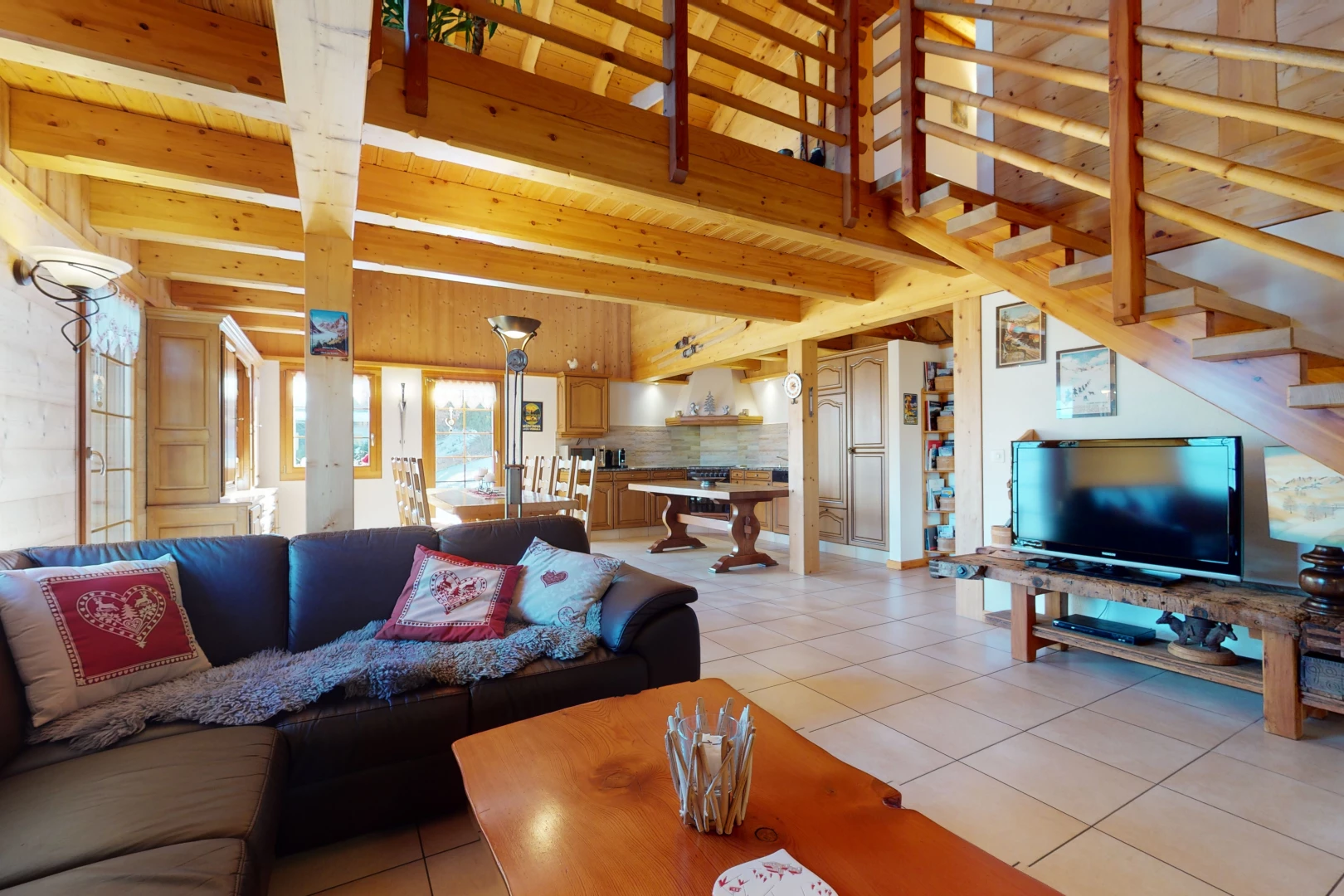 wohnzimmer mit natürlichen licht, fliesenböden, holzbalkendecke und fernseher