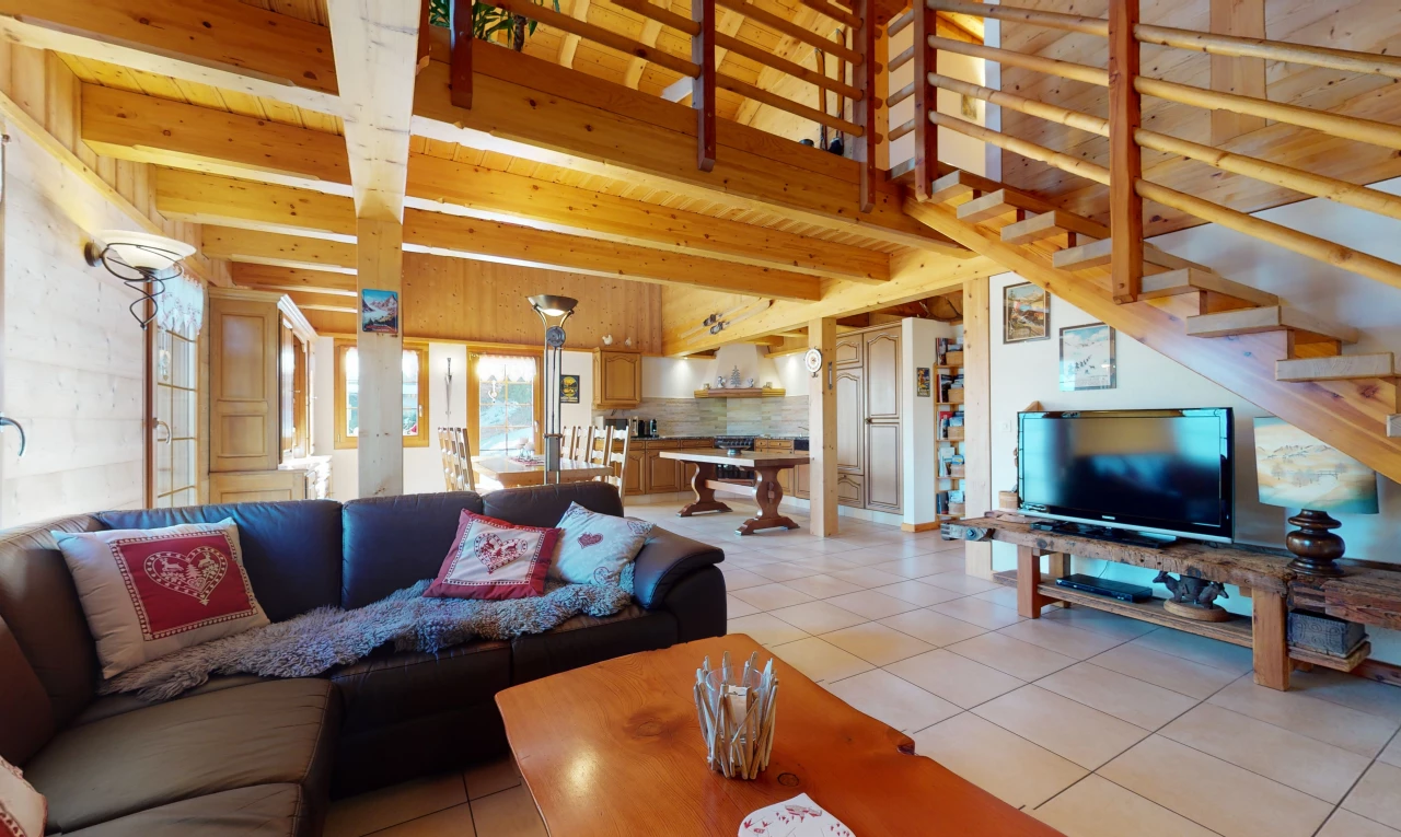 wohnzimmer mit natürlichen licht, fliesenböden, holzbalkendecke und fernseher