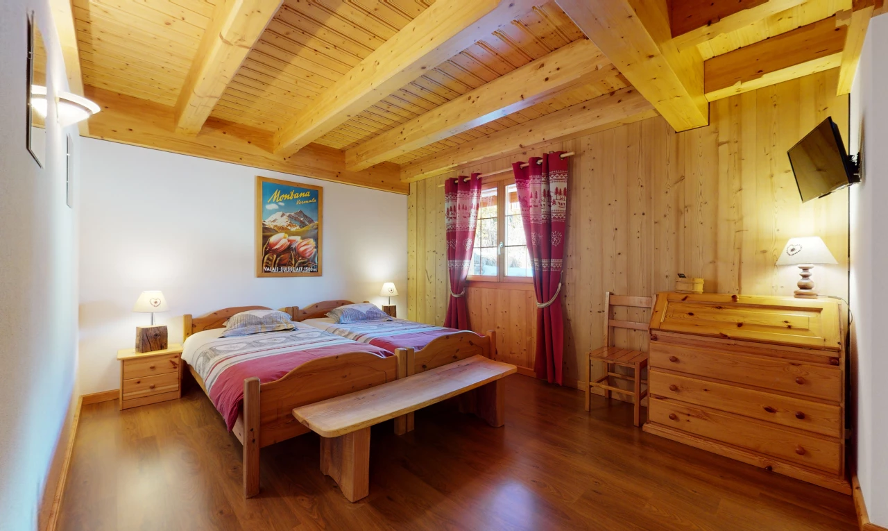 schlafzimmer mit holzböden, balkendecke, natürliches licht und fernseher