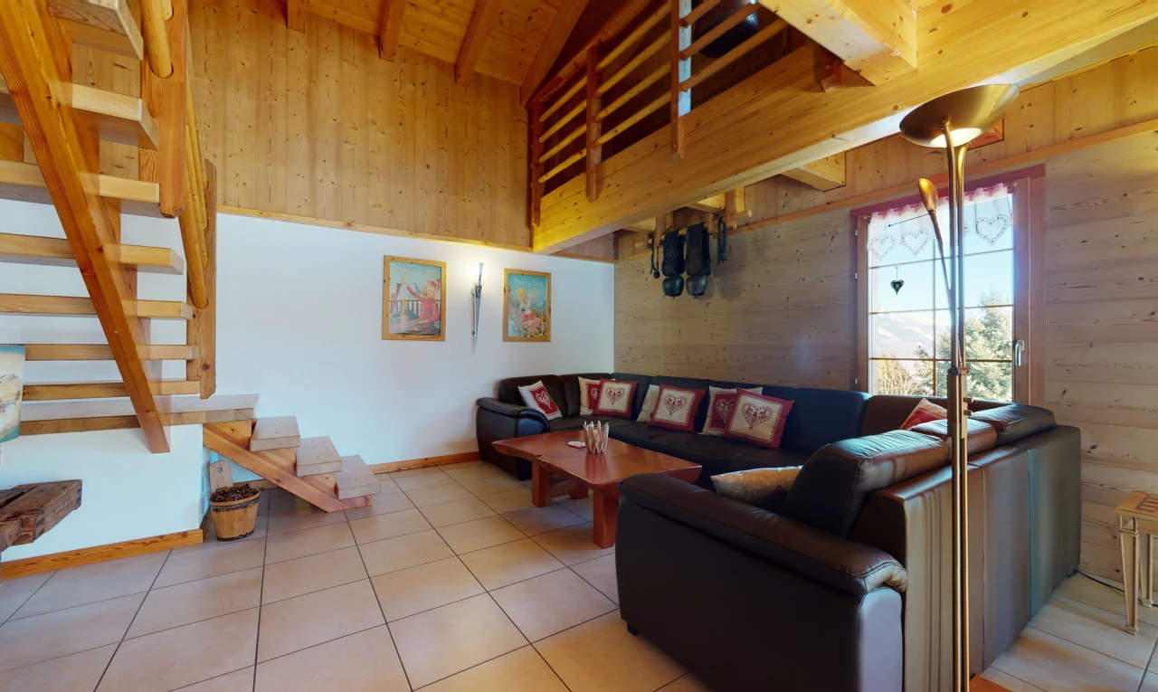 gefliestes wohnzimmer mit dachschräge mit balken und natürlichem licht