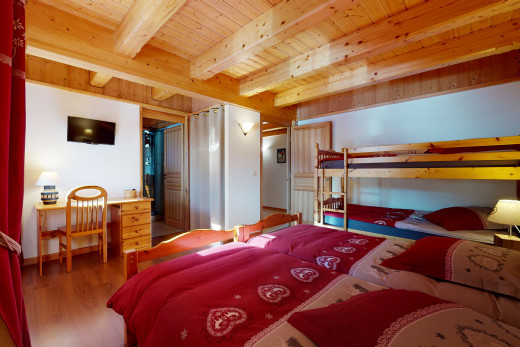 chambre à coucher avec parquet, poutres apparentes, et télévision