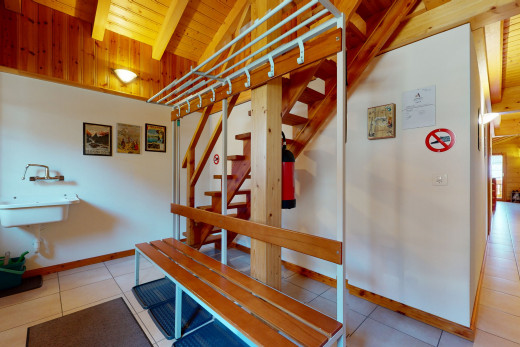 couloir avec plafond voûté, carrelage, et poutres apparentes