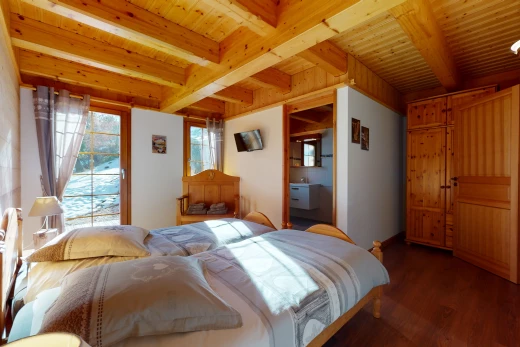 hartholzbodenschlafzimmer mit mehreren fenstern, holzbalkendecke und fernseher
