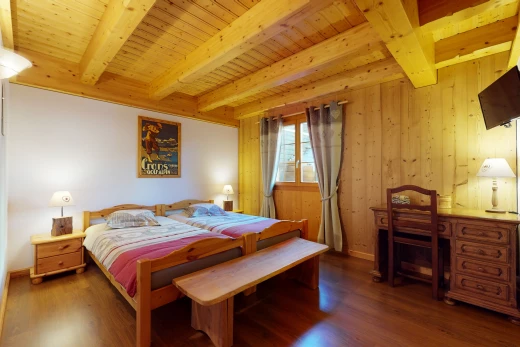 schlafzimmer mit natürlicher licht, balkendecke, hartholzboden und fernseher
