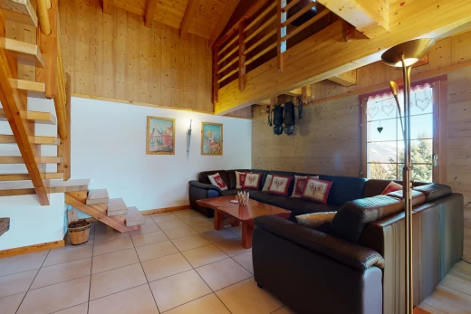 gefliestes wohnzimmer mit dachschräge mit balken und natürlichem licht