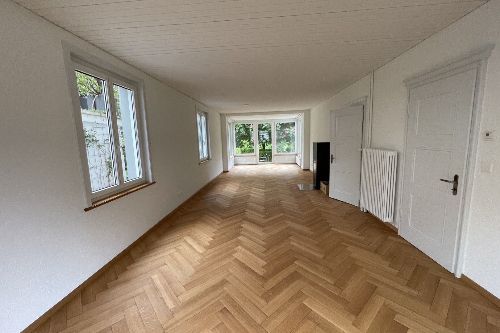 corridor featuring radiator heating unit and parquet floors