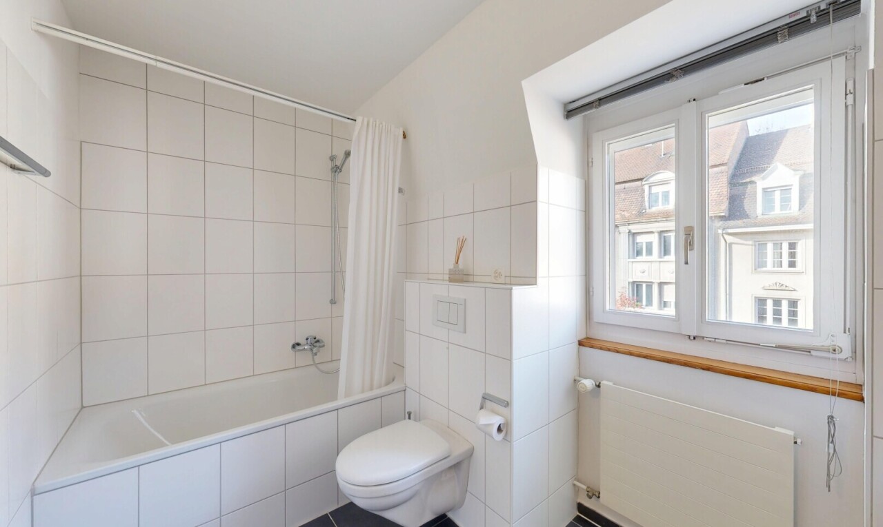 bathroom featuring radiator heating unit, tiled shower / bath, tile walls, and dark tile patterned floors