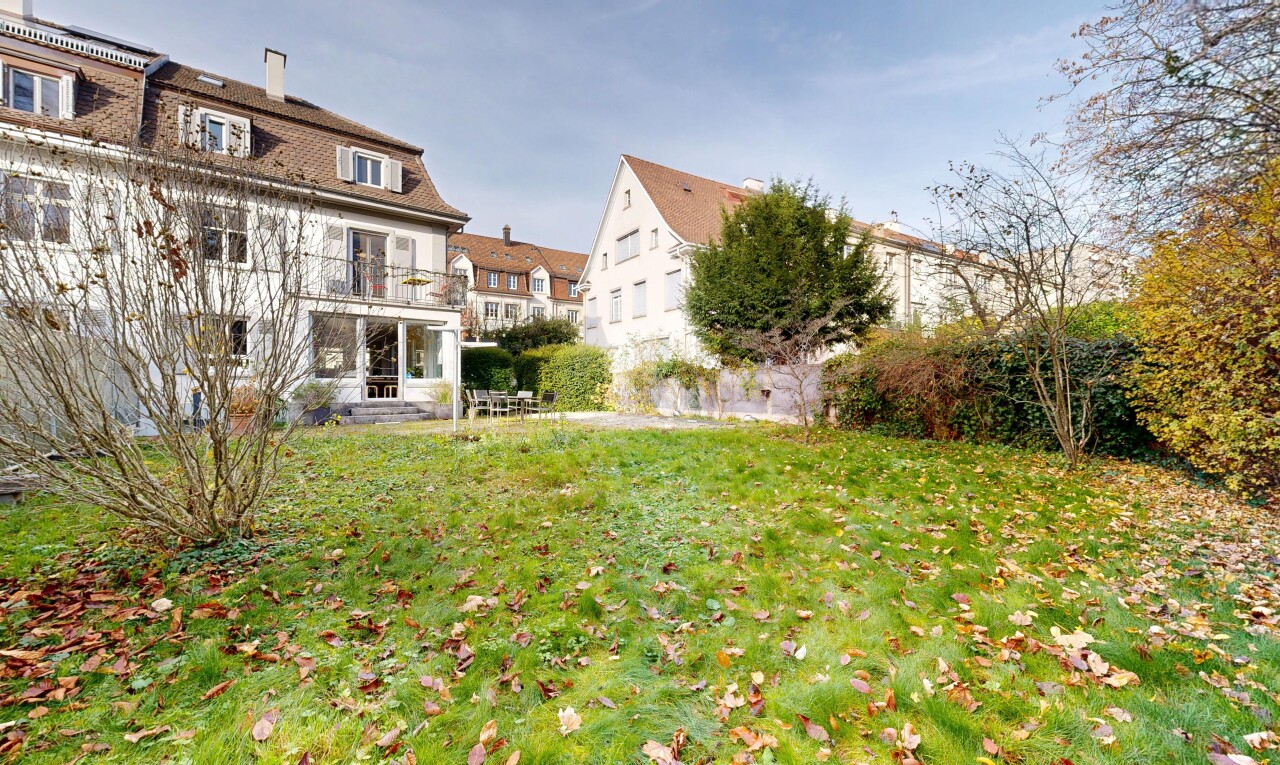 view of property with a yard, a chimney, and a balcony
