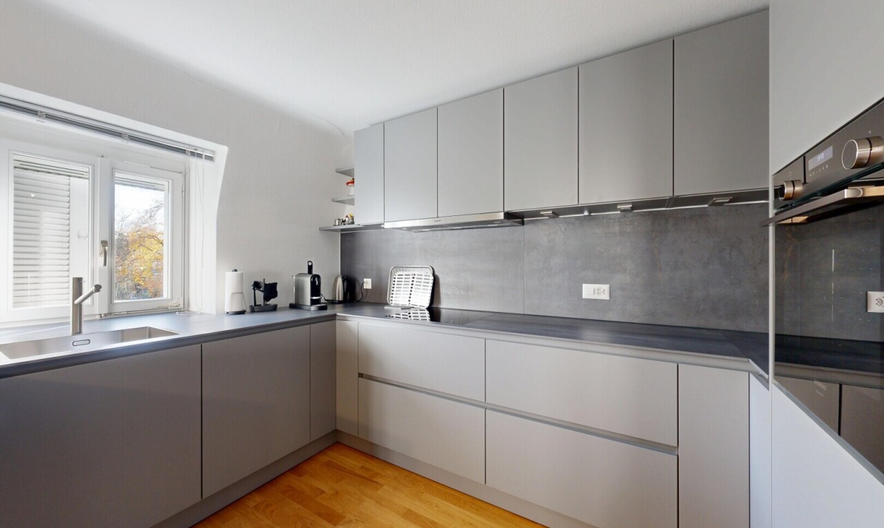 kitchen featuring gray cabinets, light wood finished floors, open shelves, black oven, and modern cabinets