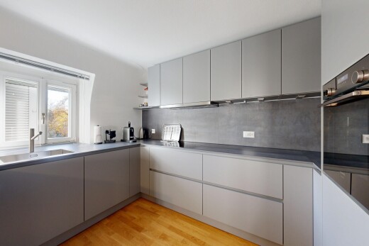 cuisine avec armoires grises, gray cabinets, sol en finition bois, wood finish floor, et light floor