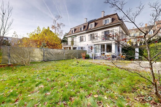 façade avec pelouse, clôture, cheminée, toit mansardé, et from property