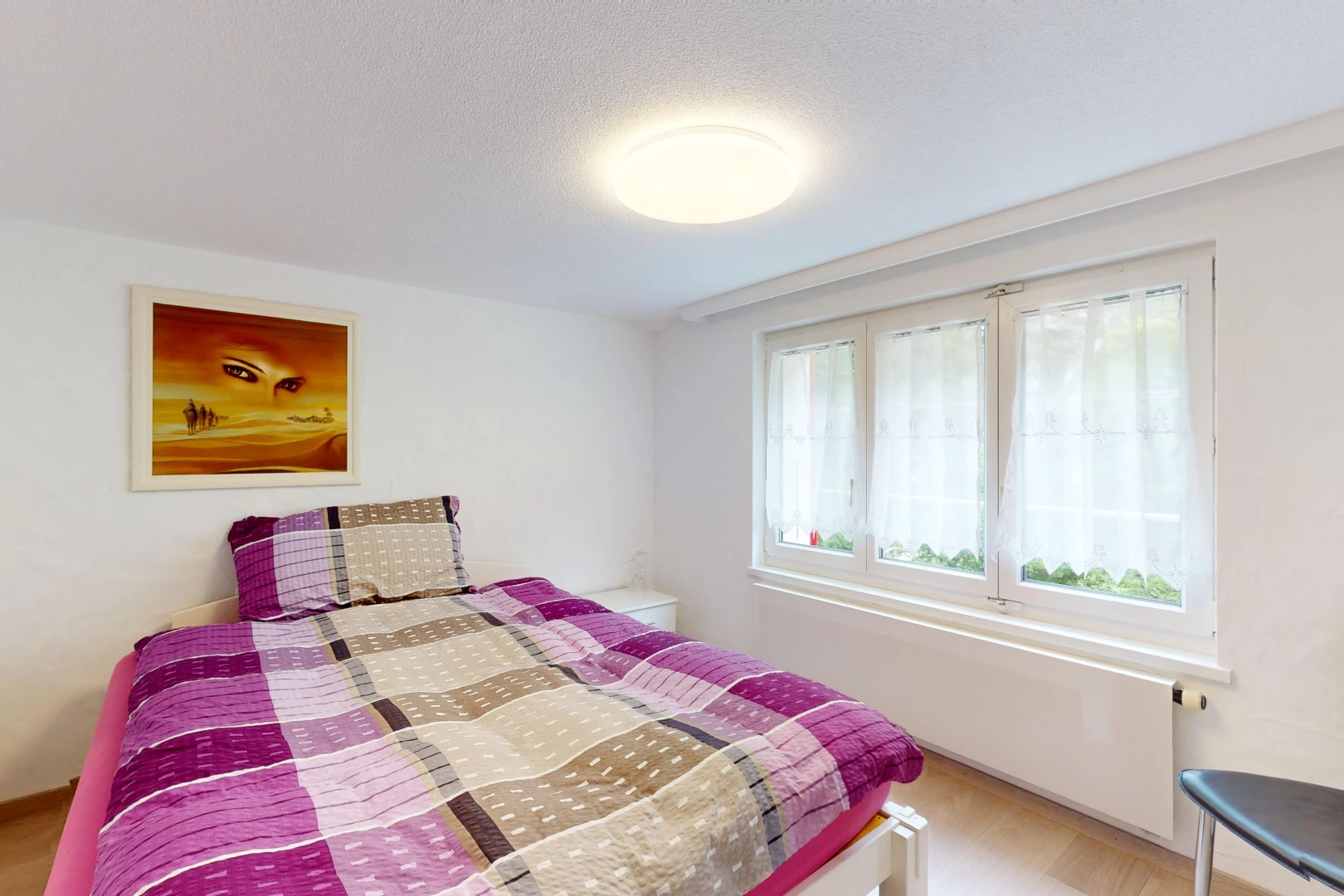 chambre avec plancher de bois et lumière naturelle