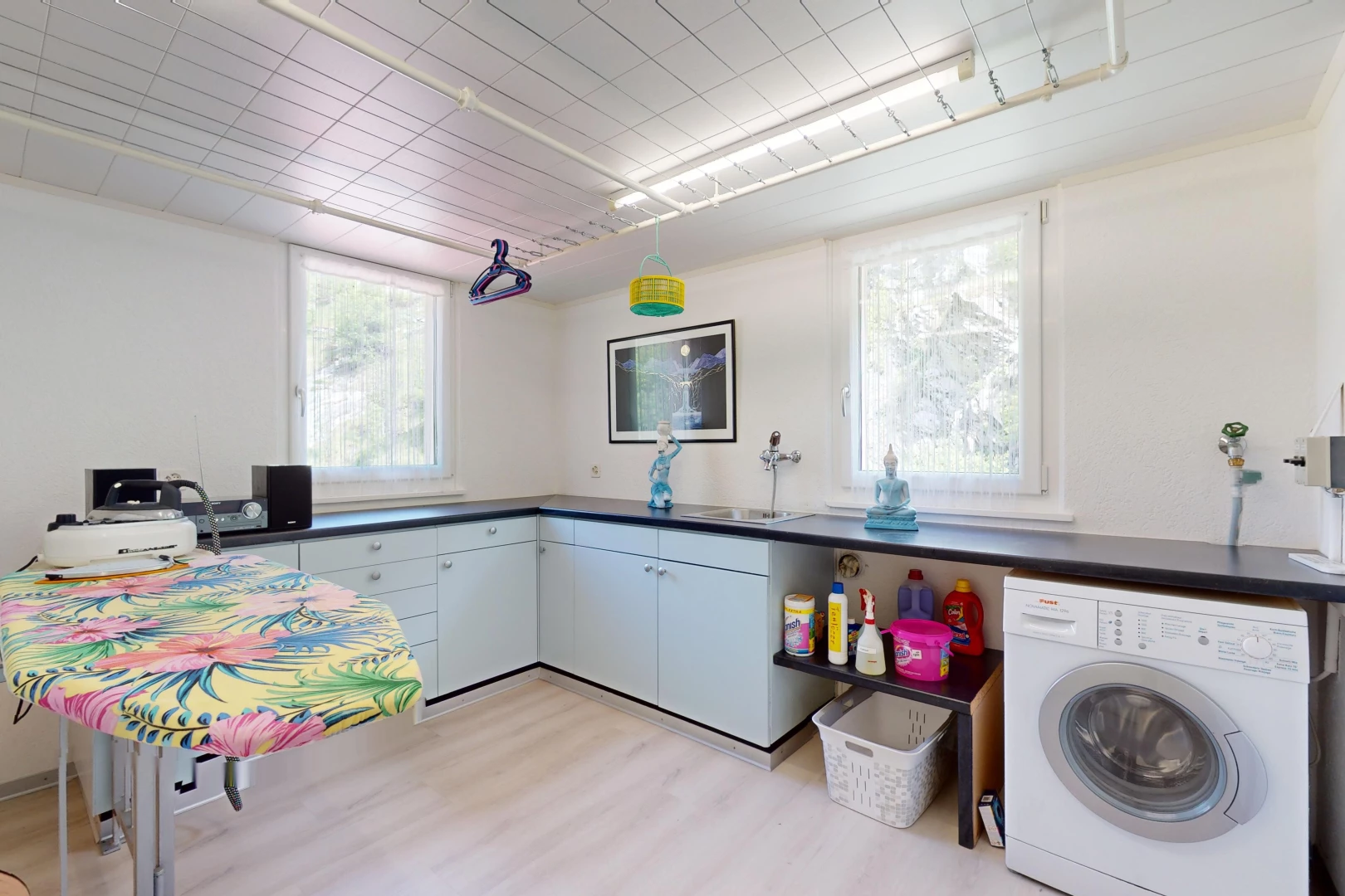 cuisine avec lumière naturelle, plancher de bois, plan de travail, et machine à laver / sèche-linge