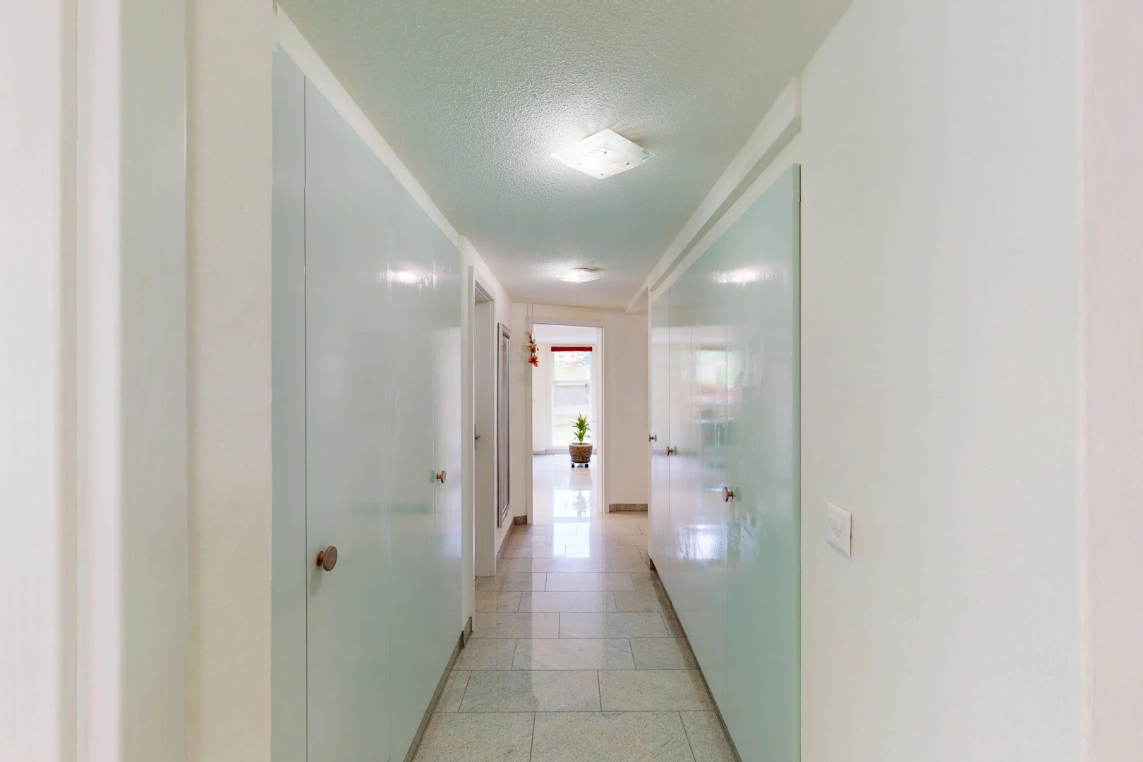 couloir avec lumière naturelle, carrelage, et plafond en crépis